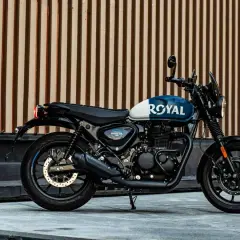 Royal Enfield Hunter 350, una moto negra y azul con el logo "ROYAL" en el tanque, lista para la aventura urbana.