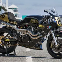 Motocicleta de carreras negra y dorada, modelo Irving Vincent, lista para la pista.