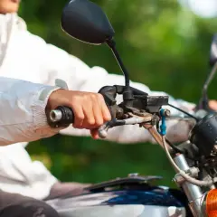 Mano sujetando el acelerador de una moto, con la llave del gas abierta, lista para la aventura.