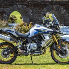 Moto Voge 500DS, una moto china con motor BMW, lista para la aventura junto a un puente de piedra.