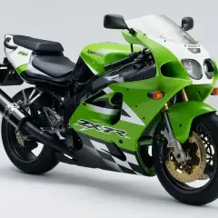 La parte posterior de una moto Kawasaki Ninja verde y blanca, con detalles de cuadros de ajedrez y un escape negro.