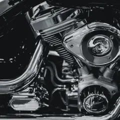 Detalle de un motor de motocicleta cromado, mostrando el sistema de alimentación y sus componentes.