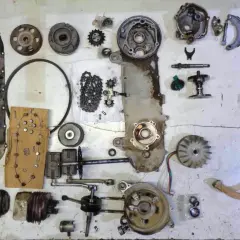 Despiece de una moto: carcasa, cadena, engranajes, cigüeñal, pistón, ventilador, escape y otras partes.