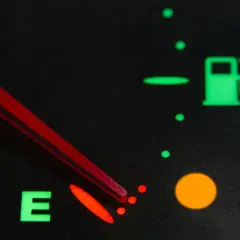 Indicador de combustible casi vacío, con la aguja roja apuntando a la 'E'. La luz de reserva está encendida. Así sabrás como saber si la llave del gas está abierta.