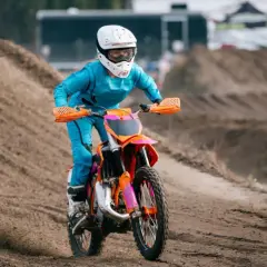 Piloto en moto 50cc azul y naranja compite en circuito de tierra. ¡Sorprende cuanto corre una 50cc!