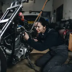 Mecánica arregla una moto ahogada en su taller.