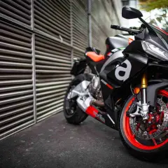 Aprilia RS 660, una moto deportiva negra con detalles rojos y naranjas, lista para la acción.