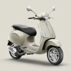 Vespa Primavera 50 color arena, con asiento negro y detalles cromados. Ideal para paseos urbanos.