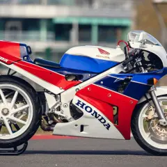 La icónica Honda RC30 VFR750R, con su distintivo tricolor rojo, blanco y azul, lista para la pista.