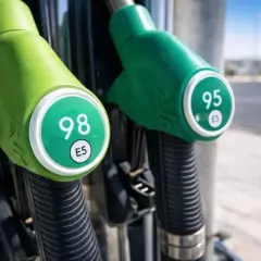 Dos boquillas de gasolina, una con 98 y otra con 95, listas para repostar tu moto.