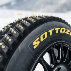 Neumático Sottozero con ruedas con clavos dorados, listo para conquistar el hielo y la nieve.