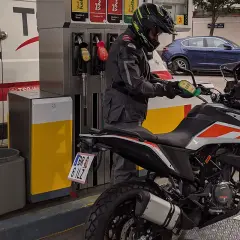 Motociclista repostando su moto 125. La pregunta clave es: ¿qué gasolina usan las motos 125? Generalmente, usan gasolina sin plomo de 95 octanos.