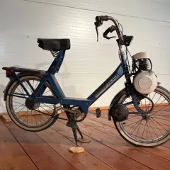 Velosolex antigua azul, un clásico de dos ruedas con motor, lista para revivir viejas aventuras.