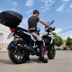 Hombre sentado en una Benelli TRK 502, mostrando la altura del asiento. La moto tiene un baúl SH59X.