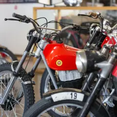 Motocicletas clásicas rojas, algunas con el número 19, que se consideran un ciclomotor.
