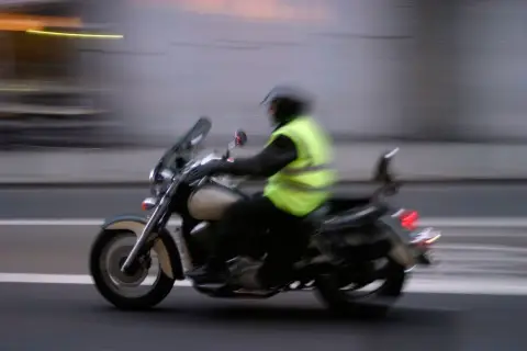 Motociclista con chaleco reflectante, esencial para la seguridad. Es obligatorio llevar chaleco reflectante en la moto.