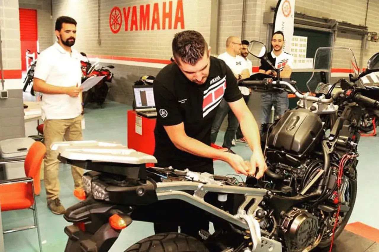 Técnicos trabajando en el motor CP3 de una motocicleta Yamaha.