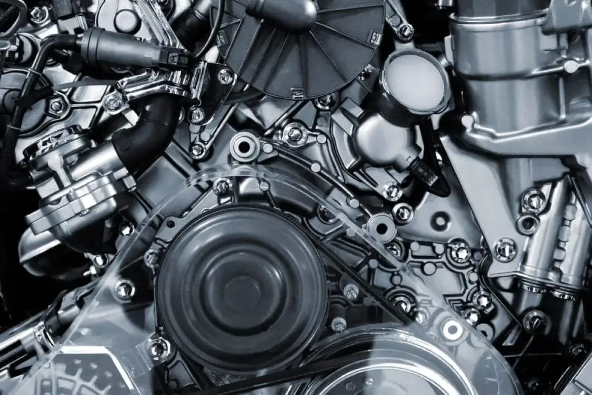 Detalle de un motor de motos 4 cilindros, con correas, poleas y componentes metálicos pulidos.