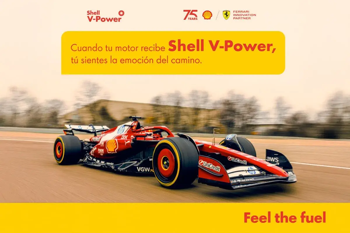 Coche de Fórmula 1 rojo y negro de Ferrari en pista, con el logo de Shell V-Power. Siente la potencia.