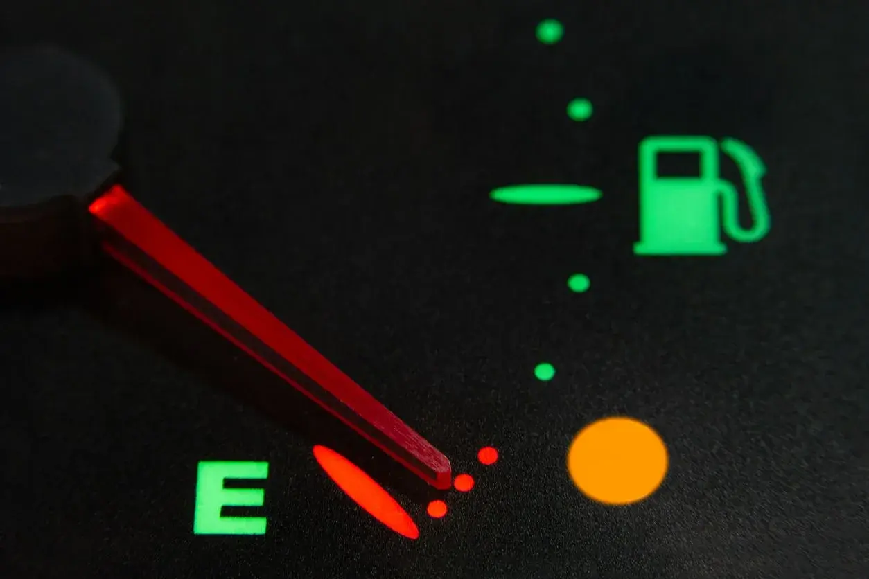 Indicador de combustible casi vacío, con la aguja roja apuntando a la 'E'. La luz de reserva está encendida. Así sabrás como saber si la llave del gas está abierta.