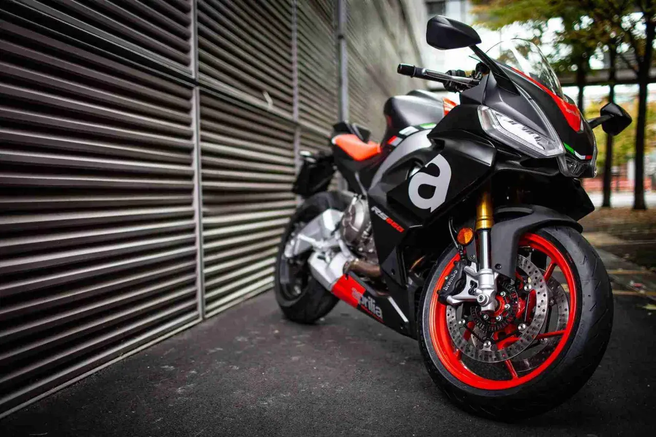 Aprilia RS 660, una moto deportiva negra con detalles rojos y naranjas, lista para la acción.