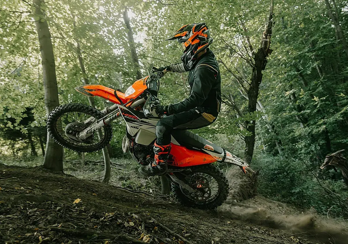 Motociclista en KTM salta en un sendero boscoso. ¡Las últimas ktm noticias sobre enduro!