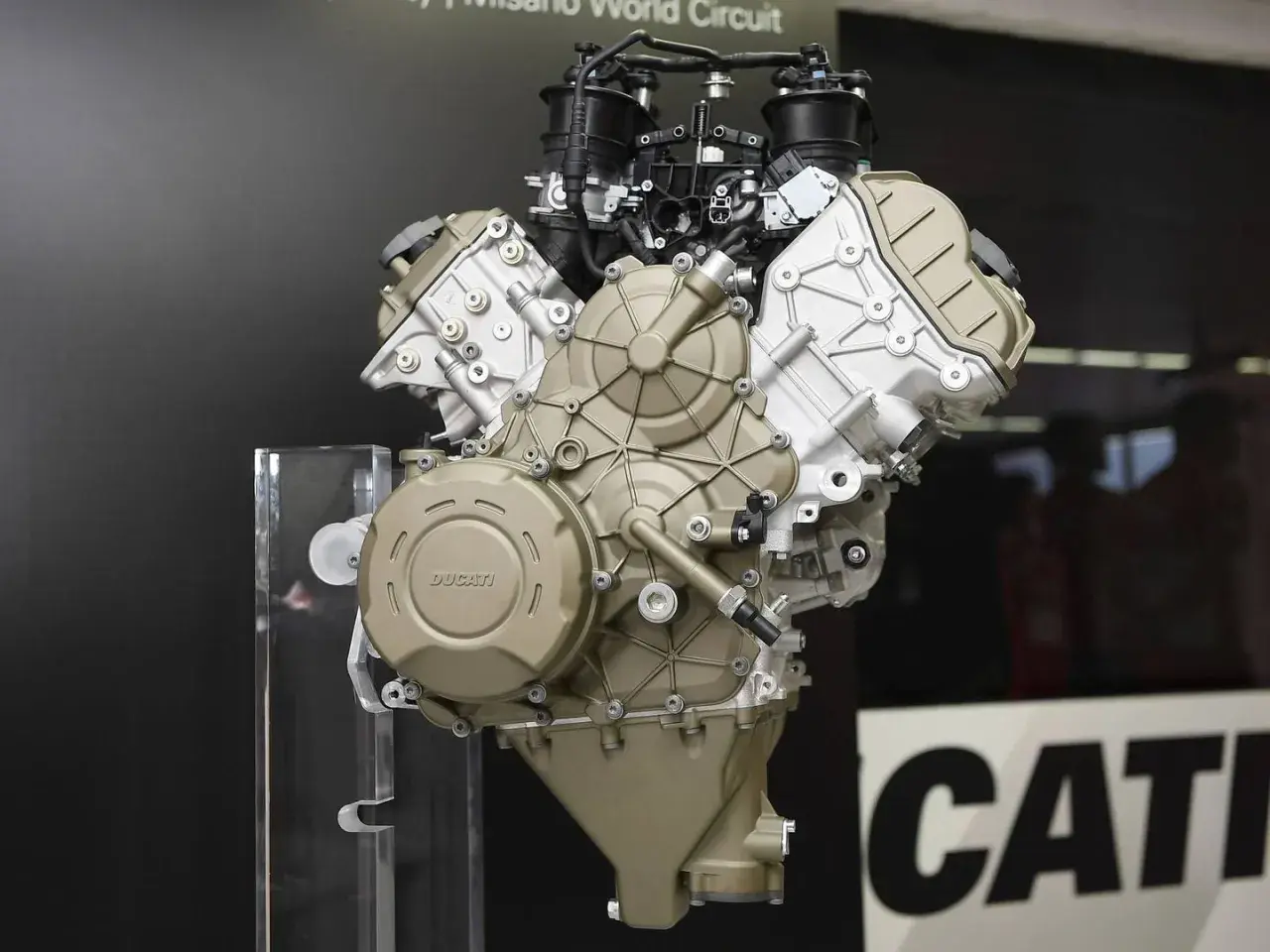 Motor V4 Ducati, una obra de ingeniería expuesta sobre un soporte transparente.