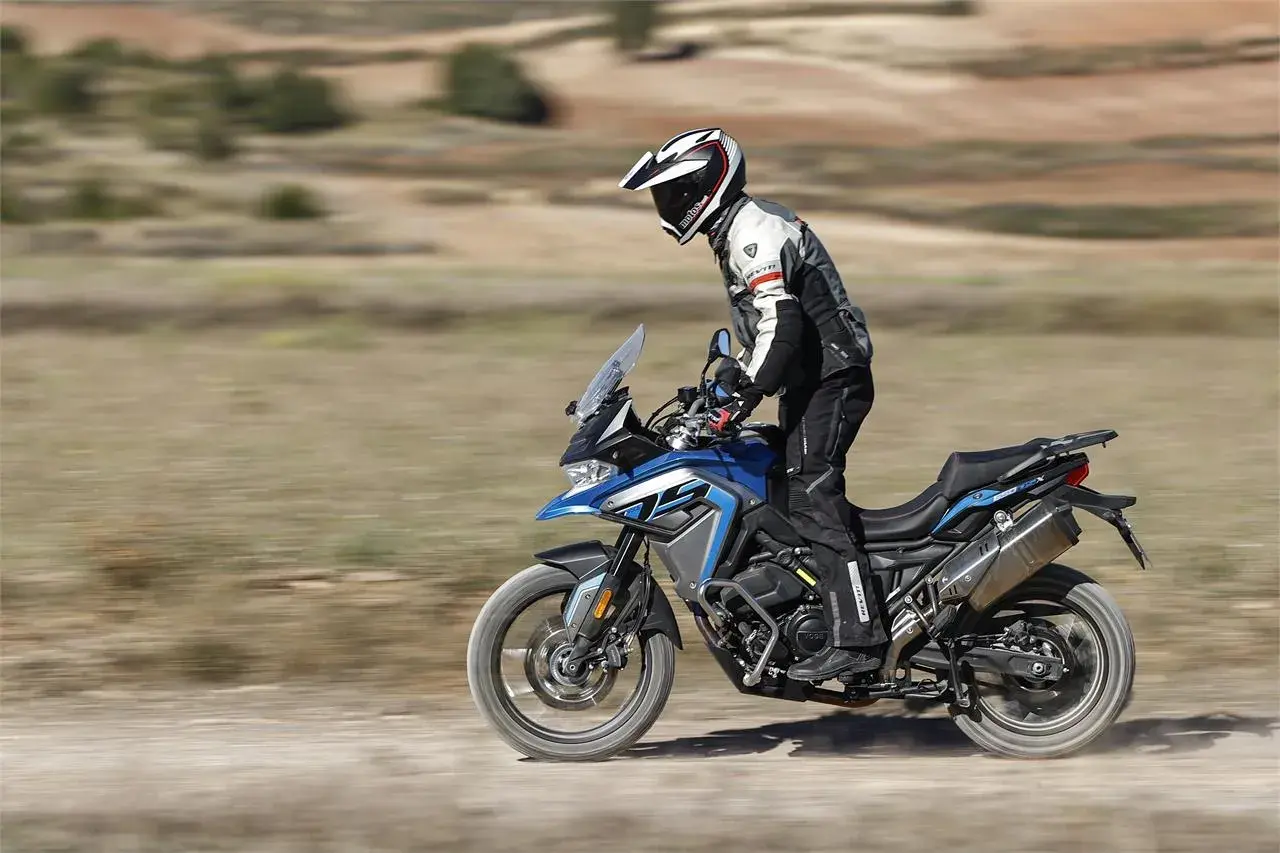 Motociclista en una Voge 650 DSX azul, probando sus capacidades off-road. Las voge 650 dsx opiniones son positivas.