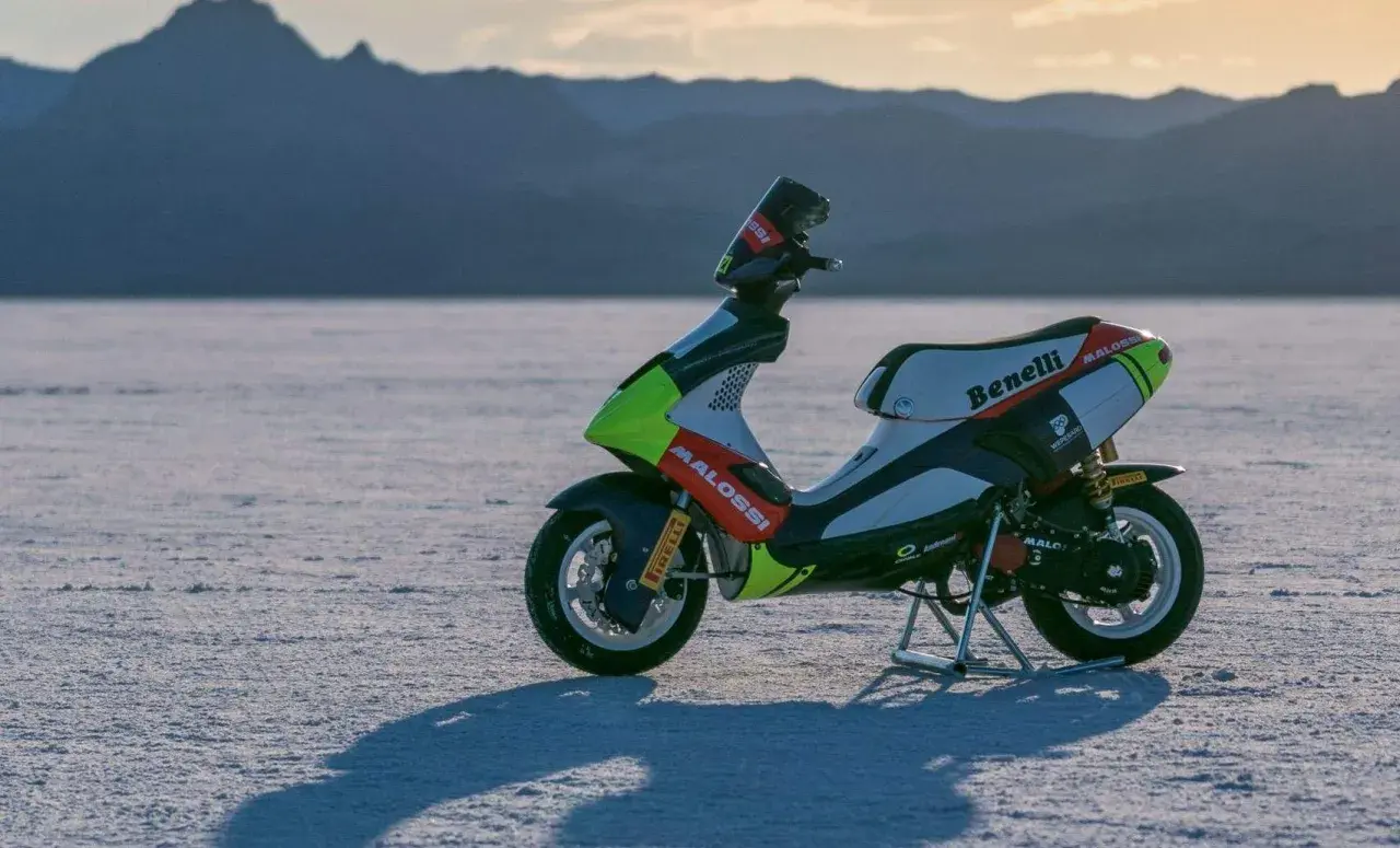 Scooter de carreras Benelli con gráficos Malossi en un paisaje desértico. ¿Cuántos caballos tiene una 49?