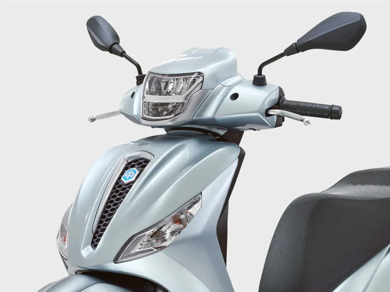 Detalle frontal de la Piaggio Medley 125 en un elegante color plateado. Se aprecian el faro, el manillar y el asiento.