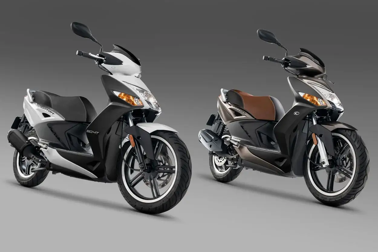 Dos scooters Kymco Agility City 50, uno blanco y negro, otro marrón y negro, listos para la ciudad.