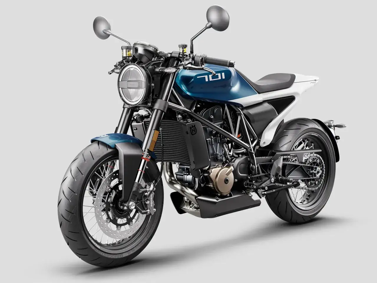 Husqvarna Vitpilen 701, una moto café racer azul y blanca con diseño minimalista y ruedas de radios.