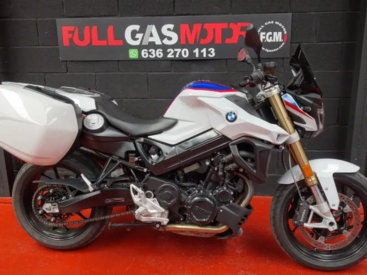 BMW F800R blanca con maletas, lista para viajar. Opiniones positivas sobre su agilidad y motor.