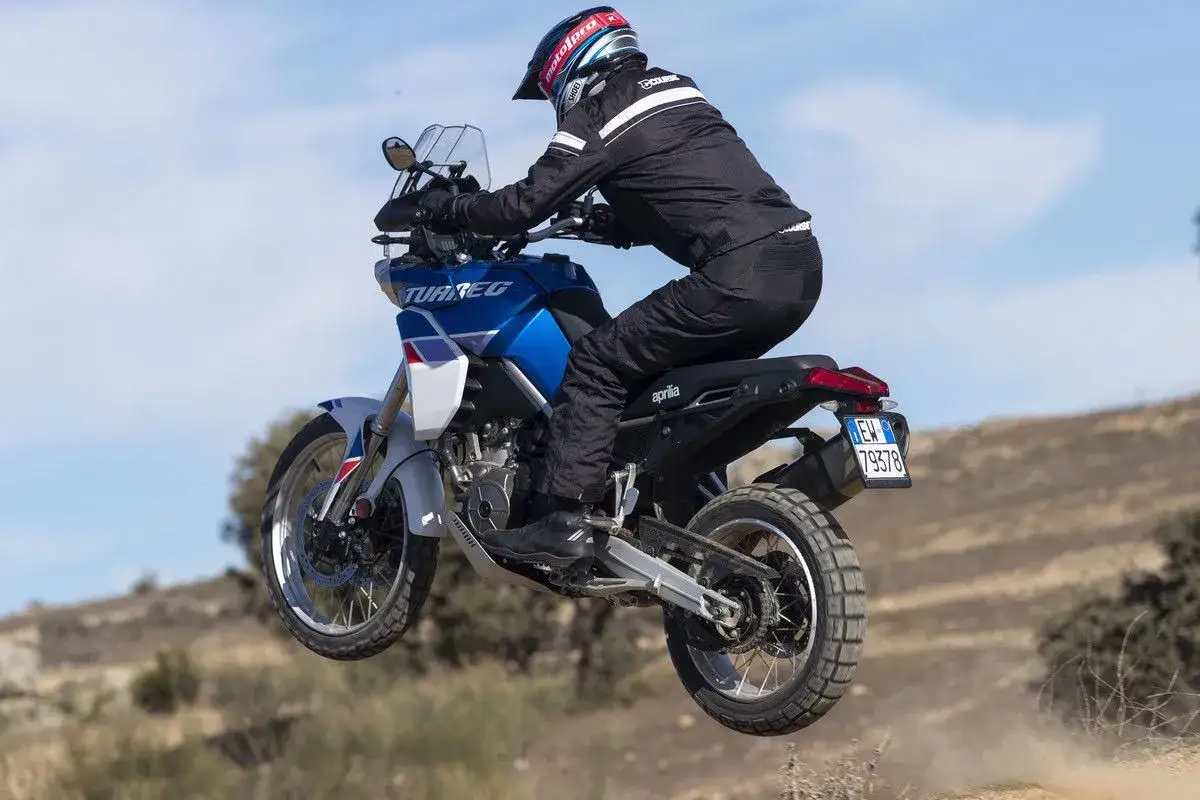 Motociclista salta en su Aprilia Tuareg 660, una moto de enduro lista para la aventura.