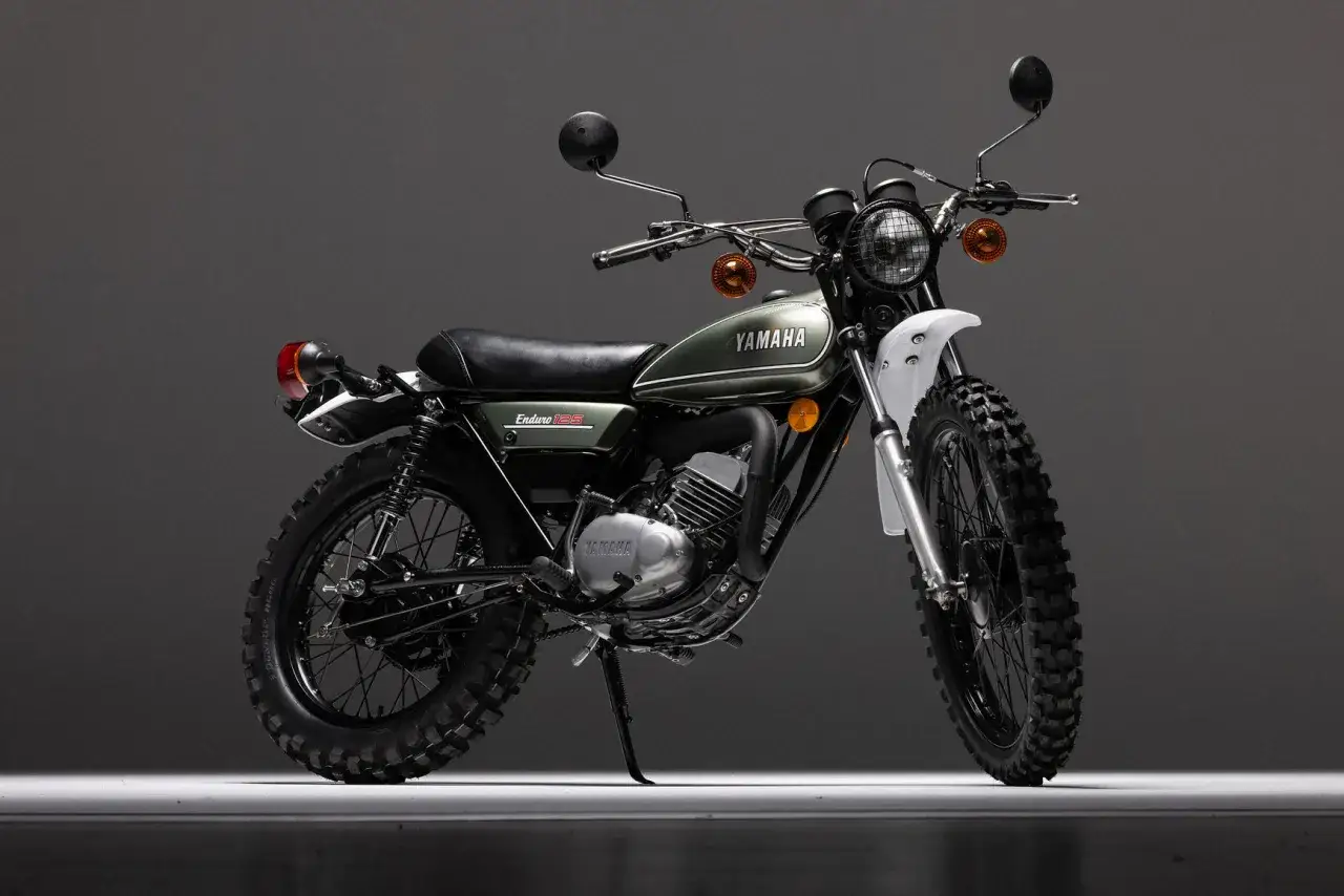 La clásica Yamaha DT 125 RE, una moto de enduro verde con detalles plateados y negros, lista para la aventura.