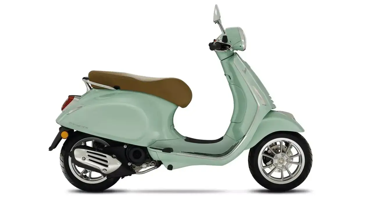 Vespa Primavera 50 en color menta, con asiento marrón y detalles cromados. Ideal para paseos urbanos.