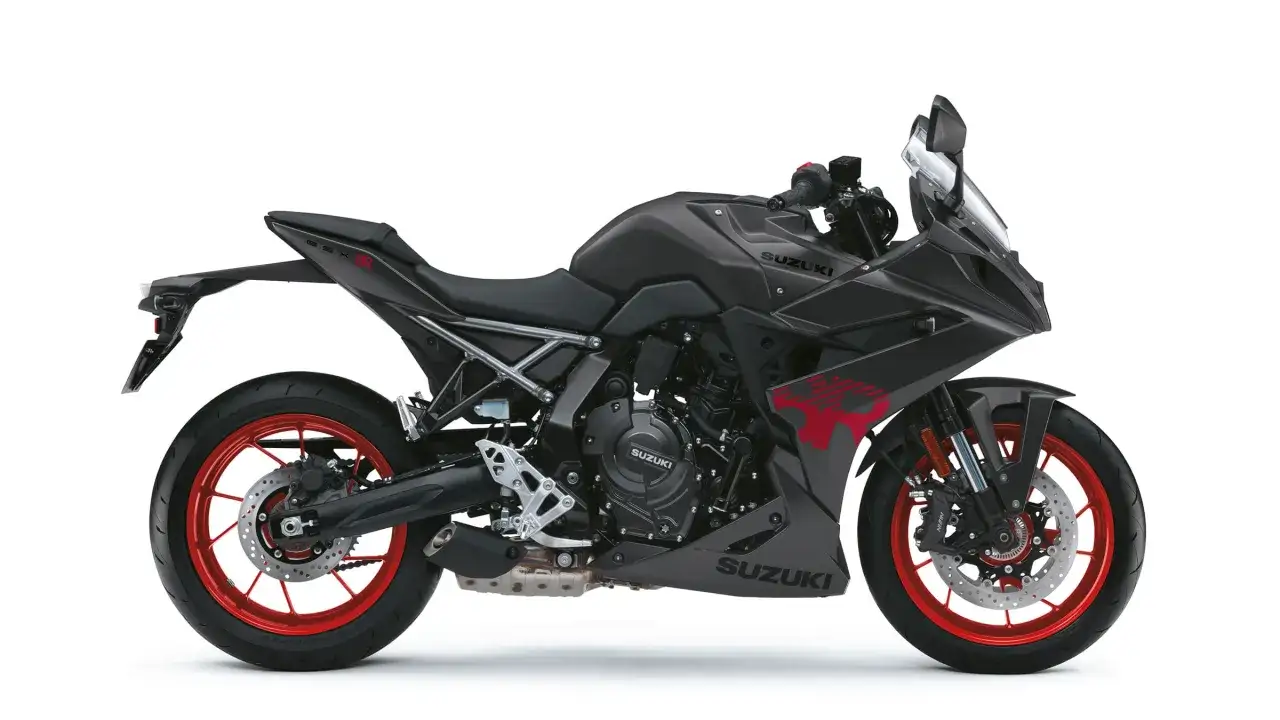 Motocicleta Suzuki GSX-8R gris oscuro con detalles rojos, llantas rojas y diseño deportivo.